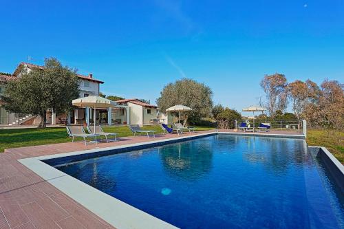 a swimming pool with chairs and a house at Agriturismo Casale Degli Ulivi Alghero in Santa Maria la Palma
