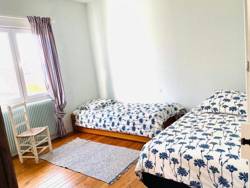 une chambre avec deux lits et une fenêtre dans l'établissement La plage au bout du jardin / Sword Beach cottage, à Hermanville-sur-Mer