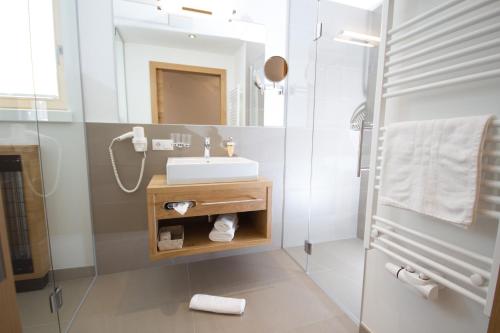 a white bathroom with a sink and a shower at Berglife Appartements in Serfaus
