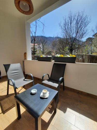 un soggiorno con tavolo, sedie e finestra di PIF Apartments Sadoveanu a Braşov