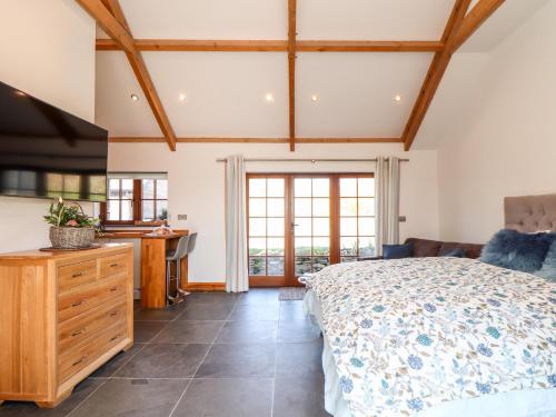 1 dormitorio con cama y tocador de madera en Rosewarrick Cottage en Bodmin