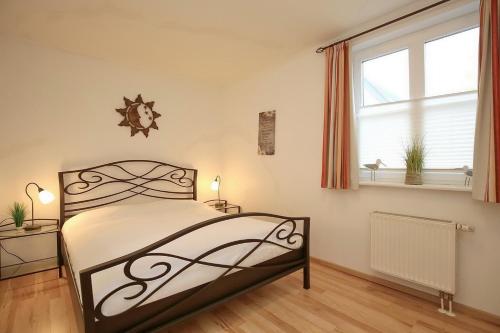 a bedroom with a bed and a window at Feriendorf Papillon Wohnung 03-1 in Boltenhagen