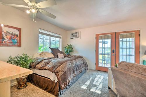 a bedroom with a bed and a couch and windows at Romantic Treetop Studio 30 Mi to Yosemite! in Coarsegold