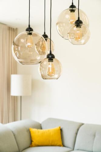 a living room with a couch and four glass lights at La Damme in Damme