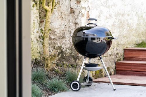 a grill sitting on a stand next to a building at La Damme in Damme