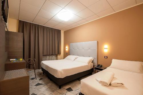 a hotel room with two beds and a television at Hotel Delle Rose in Cascia