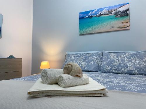 Un dormitorio con una cama con una toalla. en Il profumo del mare en Marina di Mancaversa
