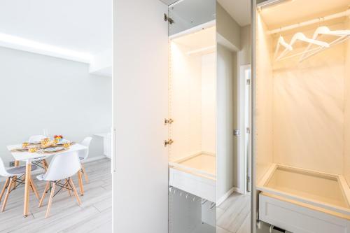 eine Küche und ein Esszimmer mit einem Tisch und einem Schrank in der Unterkunft Blue Star Luxury Apartment by Atlantic Places in Albufeira