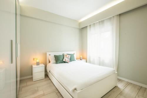 ein weißes Schlafzimmer mit einem Bett und einem Fenster in der Unterkunft Blue Star Luxury Apartment by Atlantic Places in Albufeira