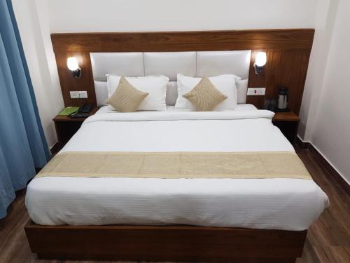 a bedroom with a large bed with white sheets and pillows at Hotel The Paal in Shimla