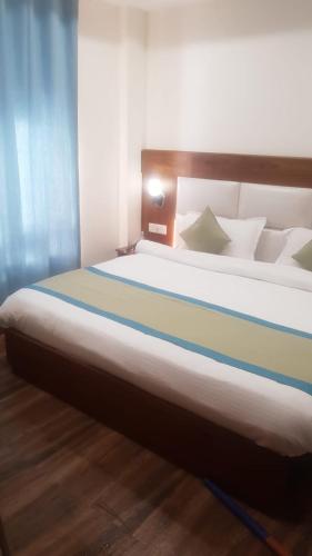 a bedroom with a large bed with a striped blanket at Hotel The Paal in Shimla