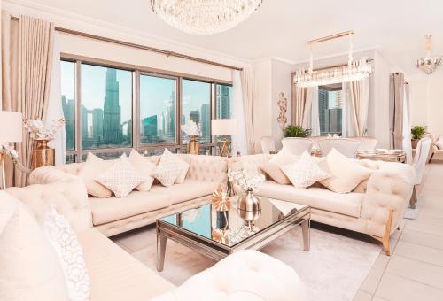 uma sala de estar com mobiliário branco e janelas grandes em Elite Royal Apartment - Panoramic Full Burj Khalifa, Fountain & Skyline view - Infinite em Dubai