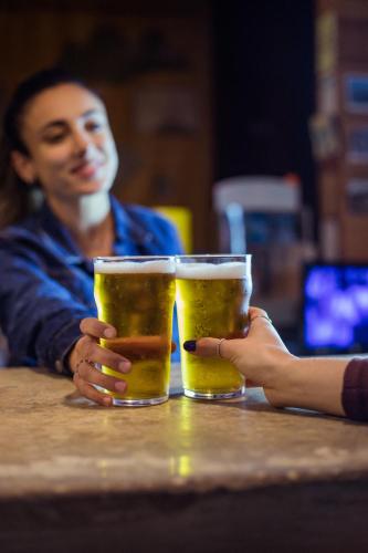 two glasses of beer on a table with a woman at Yes Lisbon Hostel in Lisbon
