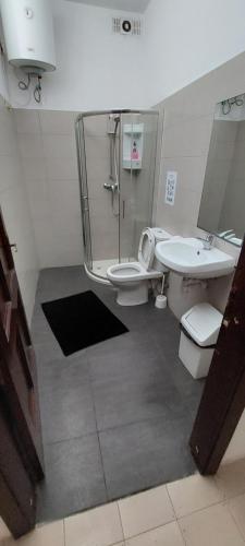 uma casa de banho com 2 WC, um chuveiro e um lavatório. em Cosy bedroom near University em Il-Gżira
