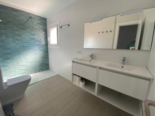 ein Badezimmer mit einem Waschbecken, einem WC und einem Spiegel in der Unterkunft Casa en Begur reformada in Begur