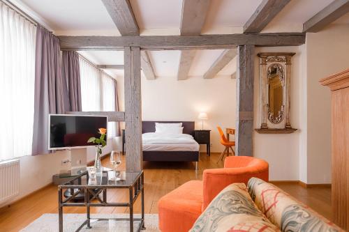 バート・ザルツフレンにあるHotel Arminiusのベッドとソファとテーブルのあるリビングルーム