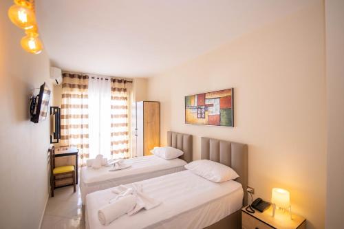 a hotel room with two beds and a window at Hotel Zanzi in Durrës
