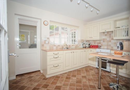 a kitchen with white cabinets and a counter top at Spacious family & dog friendly home from home with sea views and private garden in Porlock
