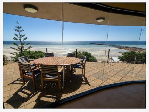 a table and chairs on a patio with a view of the beach at Cliff House Beachfront Villas in Moonta