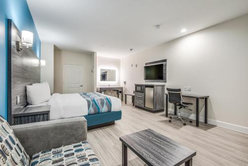 a hotel room with a king sized bed and a desk at Americas Best Value Inn & Suites Houston at Hwy 6 in Houston