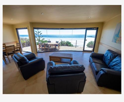 a living room with couches and a view of the ocean at Cliff House Beachfront Villas in Moonta