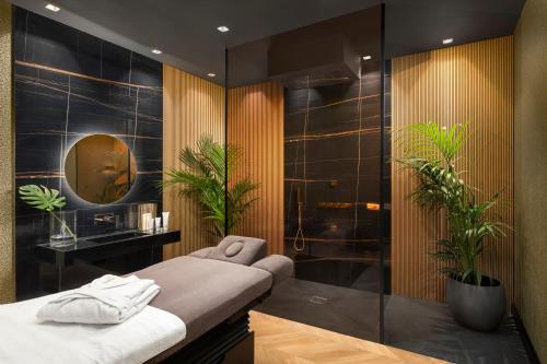 a bathroom with a shower with a bench and plants at Lure Hotel & Spa - Adults Only in Mellieħa