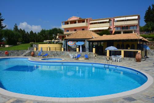 a large blue swimming pool in front of a building at Penelope Apartment Hotel in Dassia