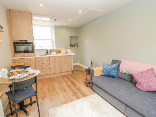 a living room with a couch and a table and a kitchen at The Print Shop in Barnard Castle