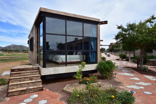 a glass house with a bed in it at Hotel Los Amantes Valle de Guadalupe in Valle de Guadalupe