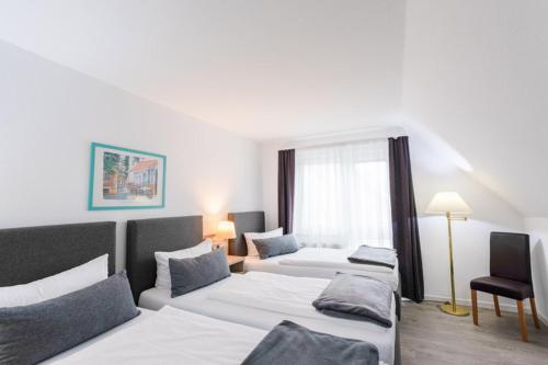 a hotel room with two beds and a window at Hotel Freihof in Stuttgart