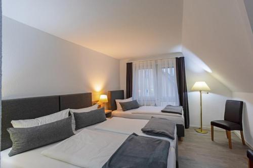 a hotel room with two beds and a window at Hotel Freihof in Stuttgart