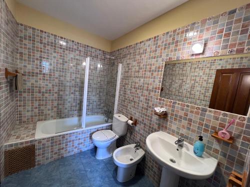 een badkamer met een wastafel, een toilet en een bad bij La Casina Del Rio in Argovejo