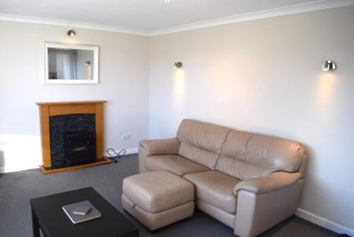 a living room with a couch and a fireplace at Kelpies Serviced Apartments- Abbotsford in Falkirk