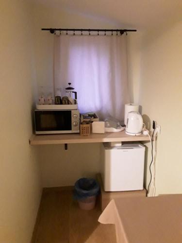 a small kitchen with a microwave on a shelf at AUSMAS in Strenči