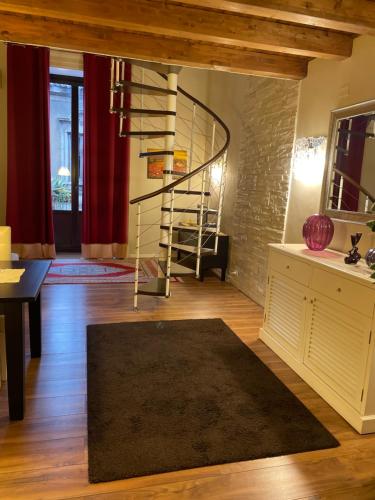 een woonkamer met een wenteltrap en een tapijt bij Katanehouse in Catania
