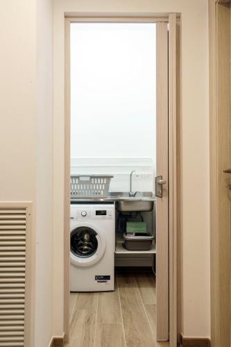 a laundry room with a washing machine and a window at Itaca in Lido di Fermo