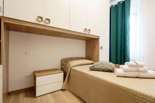 a bedroom with two beds and a window with green curtains at Itaca in Lido di Fermo
