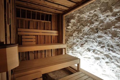 a sauna with a wooden bench in a room at Turmhotel zum Erasmus in Kelheim