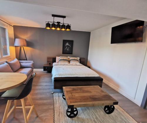 um quarto com uma cama, um sofá e uma mesa em Studio très chaleureux entièrement refait à neuf em Moulins