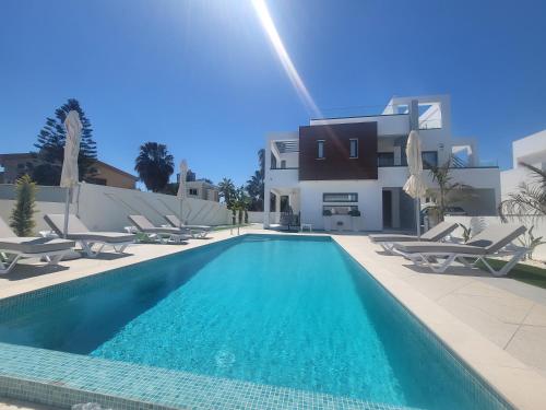 a swimming pool in front of a villa at A-Luxury Wellness Sea Villa in Ayia Napa