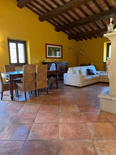 ein Wohnzimmer mit einem Sofa und einem Tisch in der Unterkunft Agriturismo Ca'Verdeselle in Fermignano