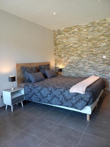 Montmorency-Beaufort"Le Studio" climatisation Parking Privé Restauration Proche des lacs的一间带床和砖墙的卧室