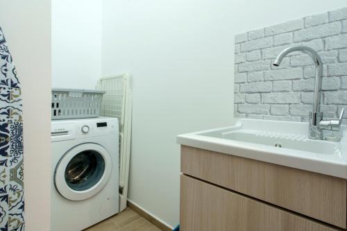 a bathroom with a washing machine and a sink at Itaca in Lido di Fermo