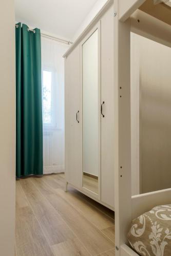 a bedroom with white cabinets and a green curtain at Itaca in Lido di Fermo