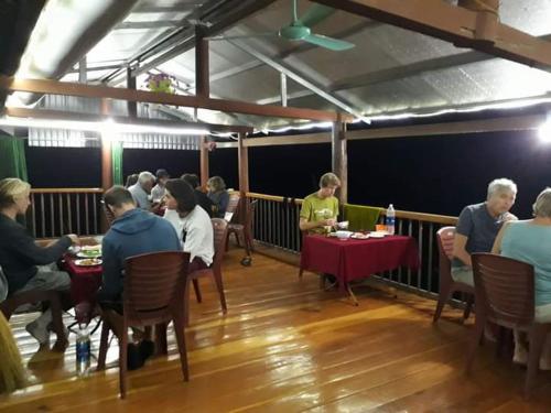 a group of people sitting at tables in a restaurant at Tran Xuan Homestay Ba Be Village in Ba Be