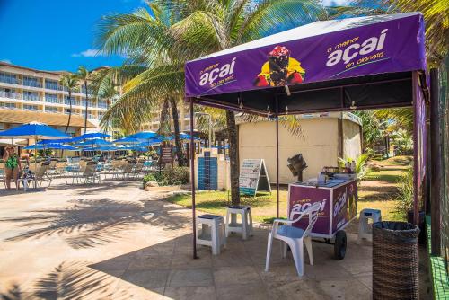 a restaurant with a purple canopy and chairs and tables at Gran Hotel Stella Maris Urban Resort & Conventions in Salvador