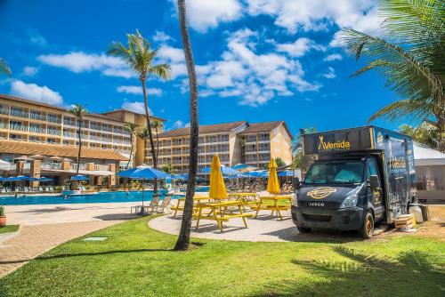 a garbage truck parked next to a pool at a resort at Gran Hotel Stella Maris Urban Resort & Conventions in Salvador