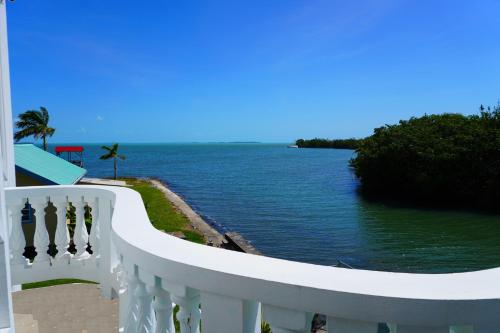 einen weißen Balkon mit Blick auf das Wasser in der Unterkunft See Belize WATERSIDE Sea View Suite with Infinity Pool & Overwater Deck in Belize City