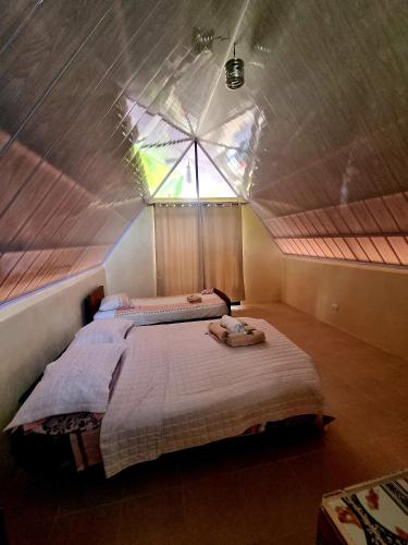 a bedroom with two beds in a room with a roof at Ballena Oasis Homes & Glamping in Uvita