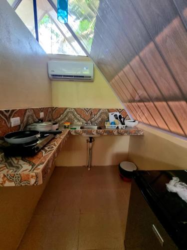 a small kitchen with a couch in a tiny house at Ballena Oasis Homes & Glamping in Uvita